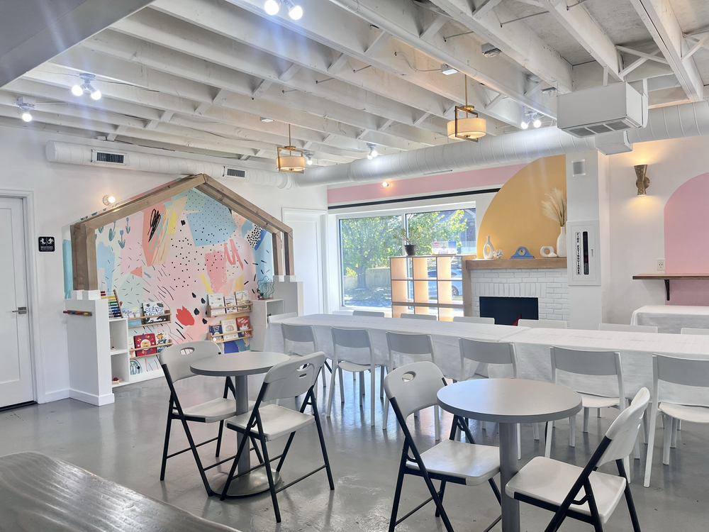 tumble HAUS DIY party space in Denver with a playhouse mural, long table, folding chairs and big windows