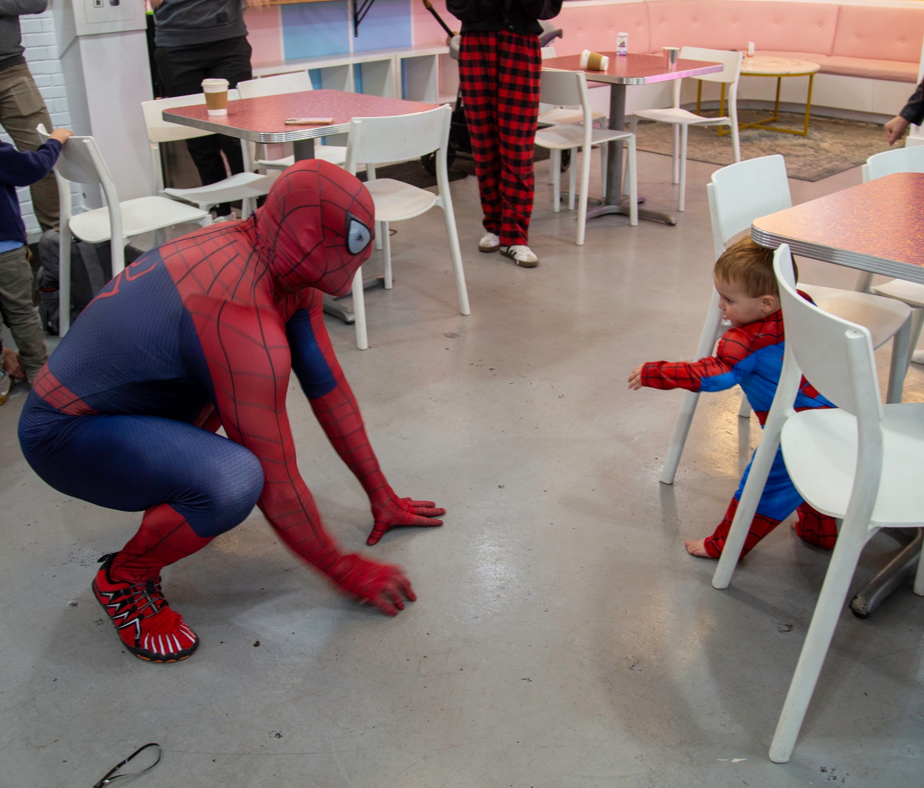 Spider-Man playing with a toddler in a Spider-Man costume at tumble HAUS Denver