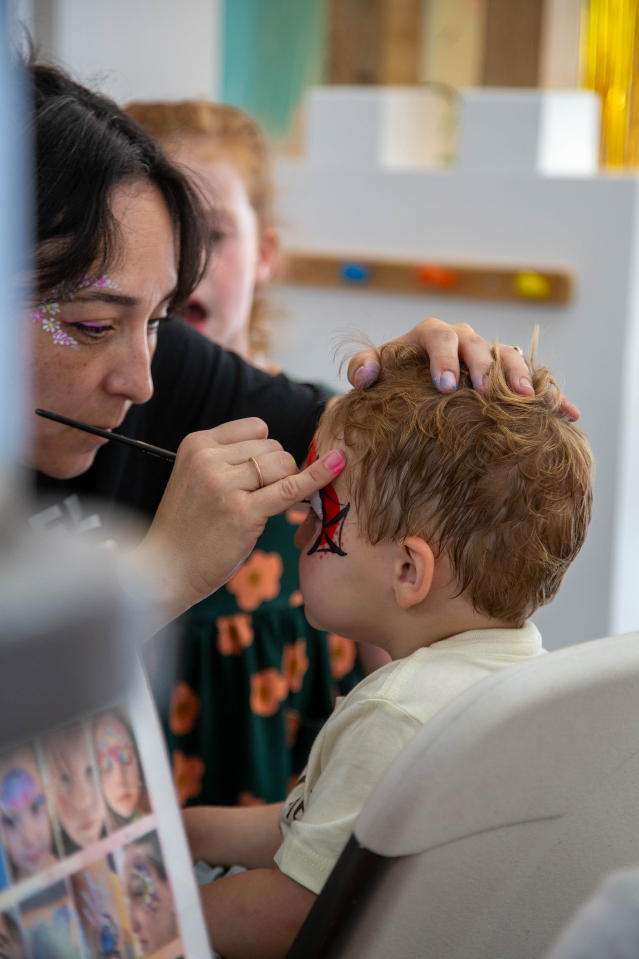 Nancy's Face Painting creating a superhero design for a child at a tumble HAUS party
