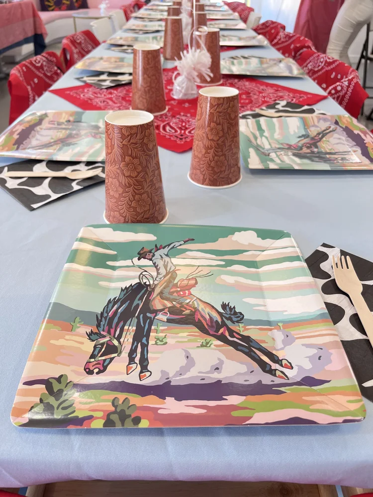 Western party table at tumble HAUS with rodeo paper plates, tooled cups and red bandana runners