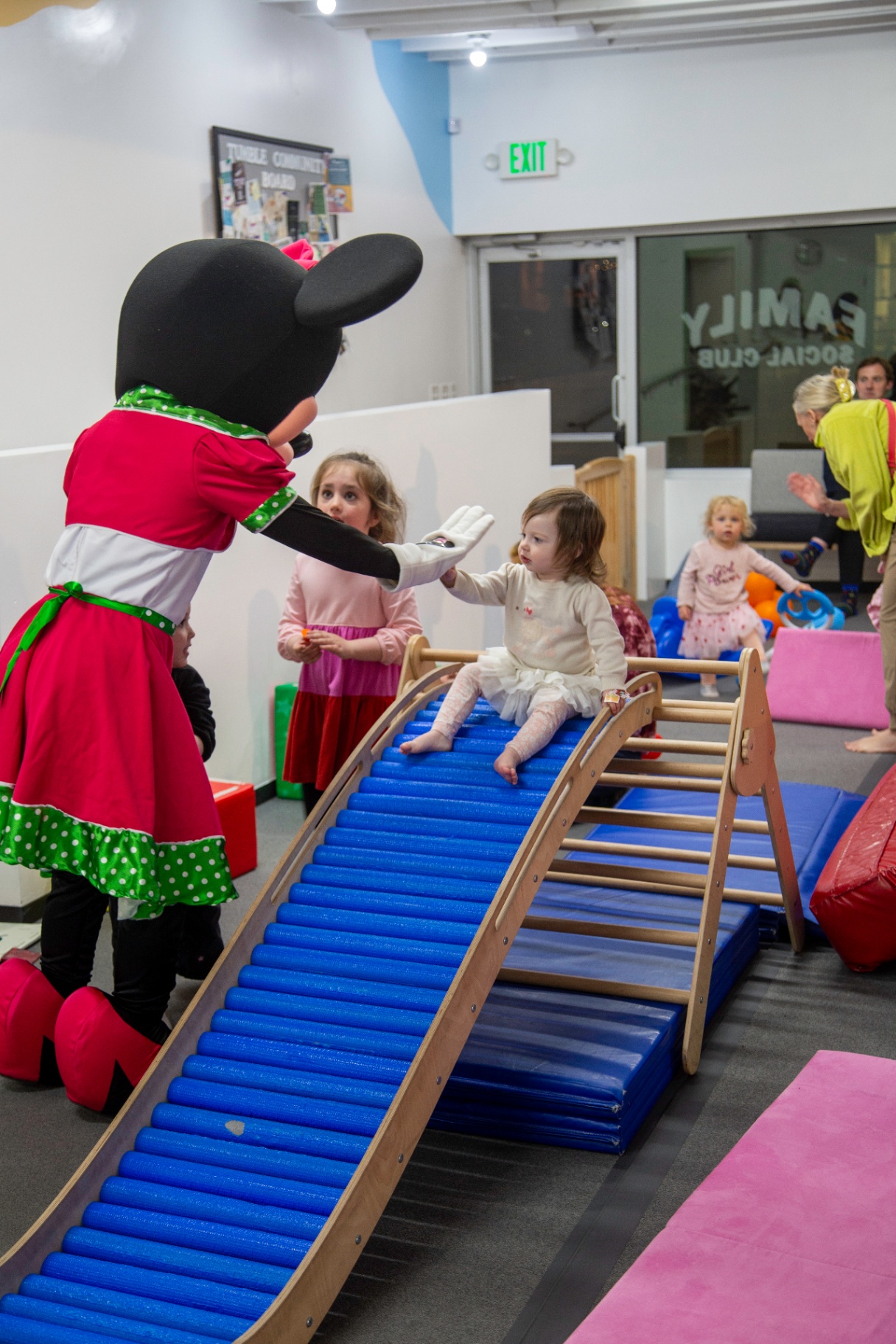 Minnie Mouse high-fiving a toddler on the ramp at tumble HAUS in Denver