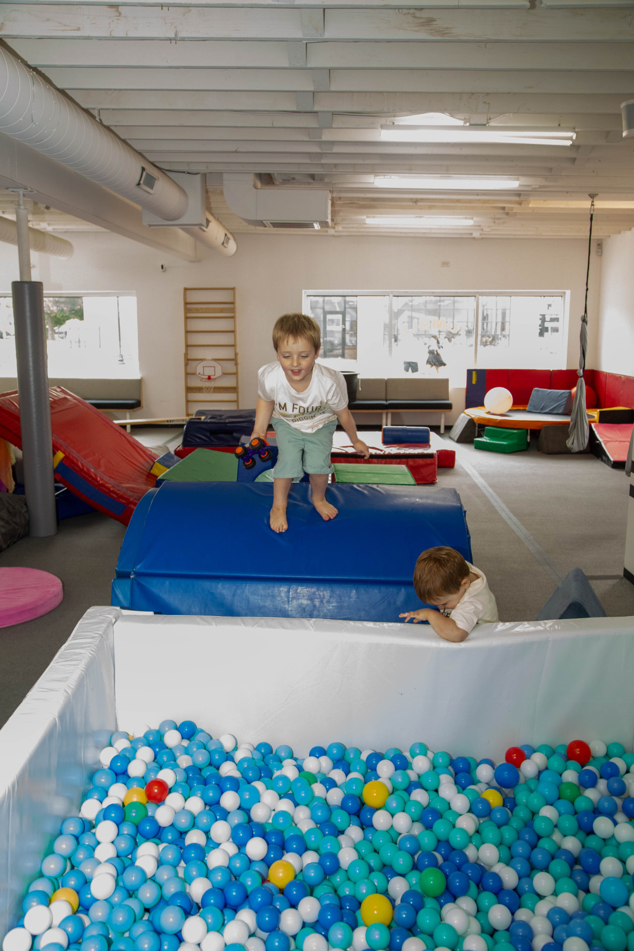 Children playing together beside the blue ball pit during a tumble HAUS birthday party