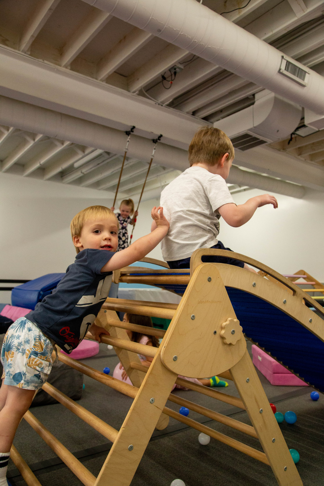 Children climbing and exploring the wooden play equipment during a private party
